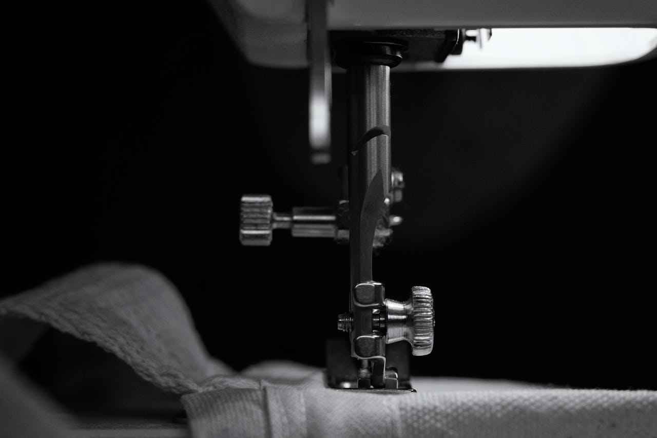 Crafting Captivating Headlines: Your awesome post title goes here Close-up of sewing machine needle stitching beige fabric in black and white.
