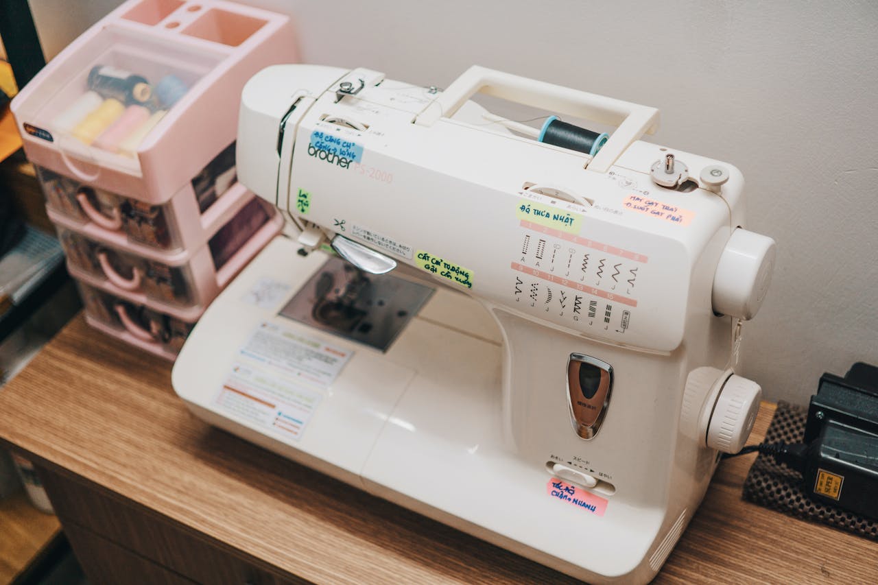 Close-up of a sewing machine and threads in a workshop setting.