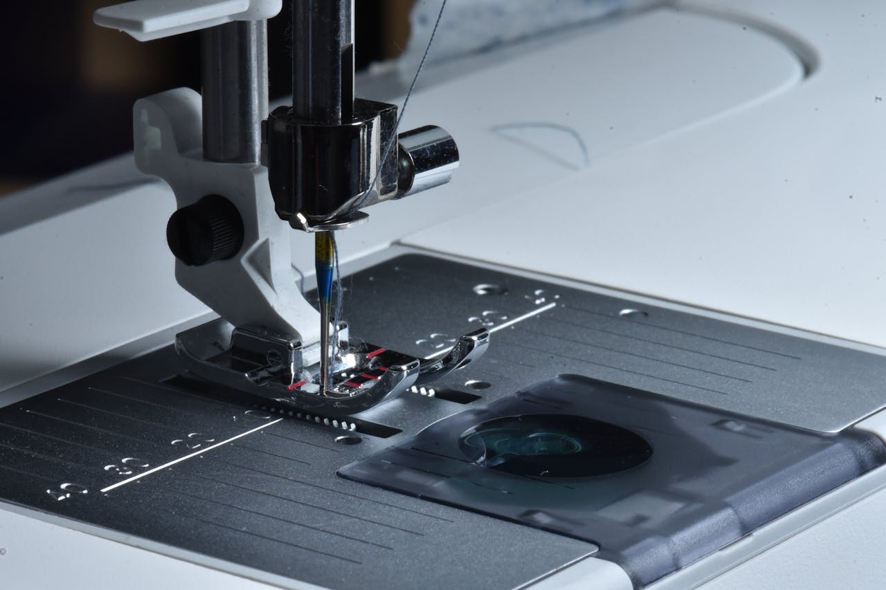 Home Detailed view of a sewing machine needle and presser foot on a sewing machine.